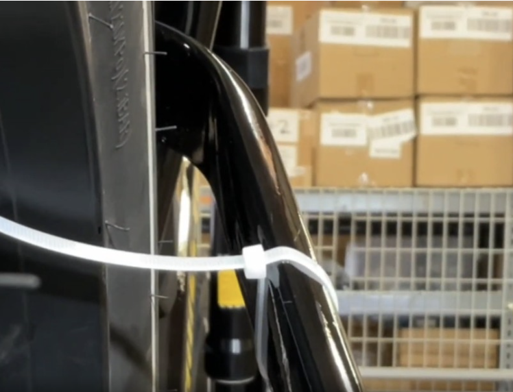 Zip tie positioned around the swing arm near the rim