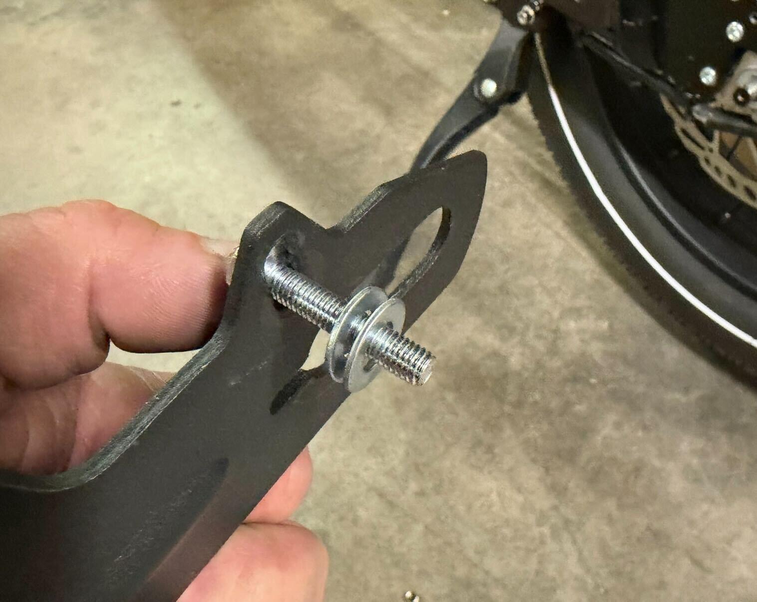 Washers placed on screw between bracket and frame