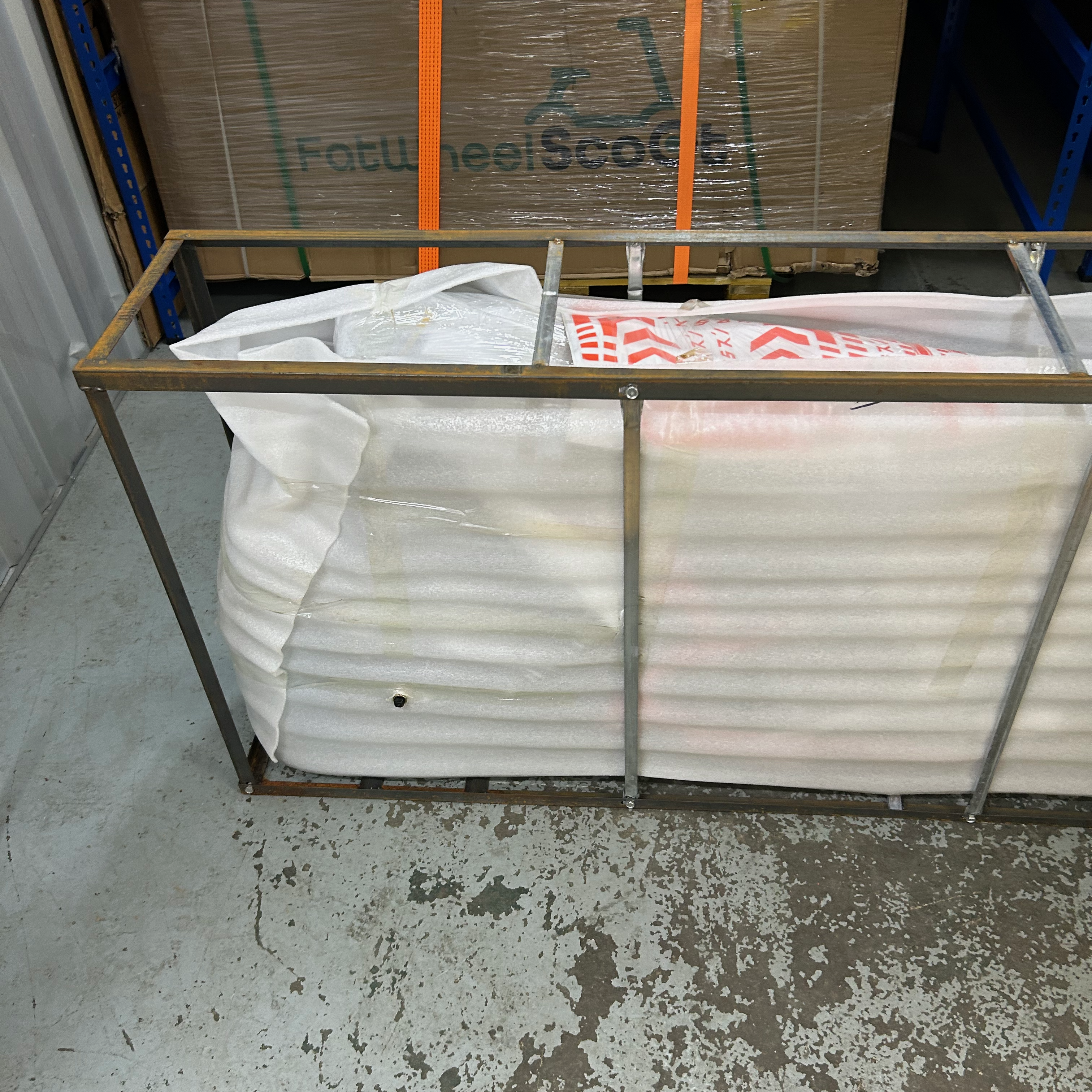 Scooter wrapped with white protective wrapping inside its metal frame