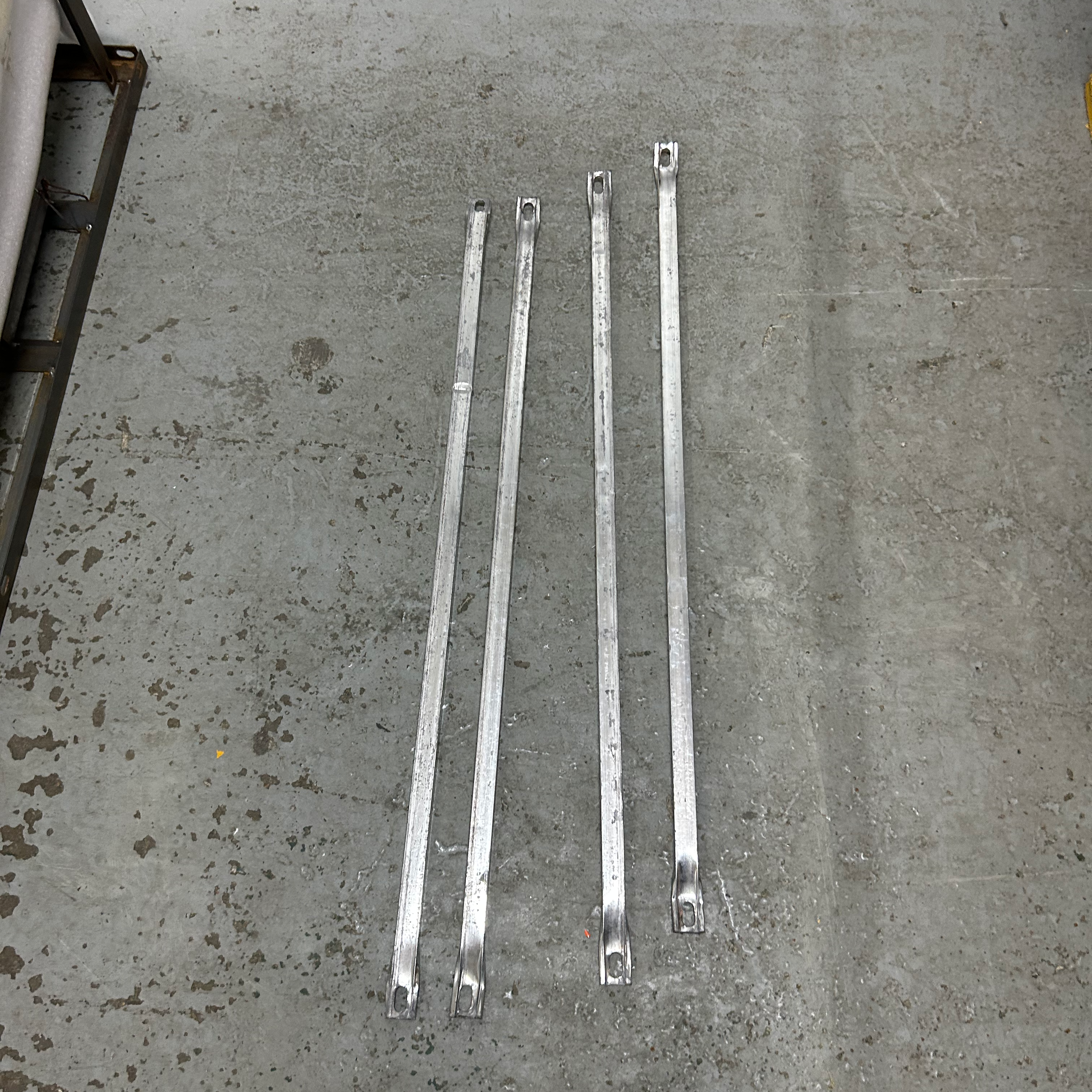 Four metal straps on a concrete floor