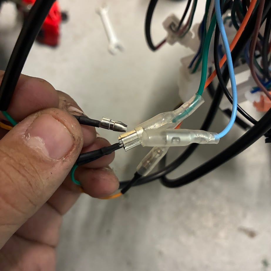 Hand holding a bundle of wires with connectors against a blurred background