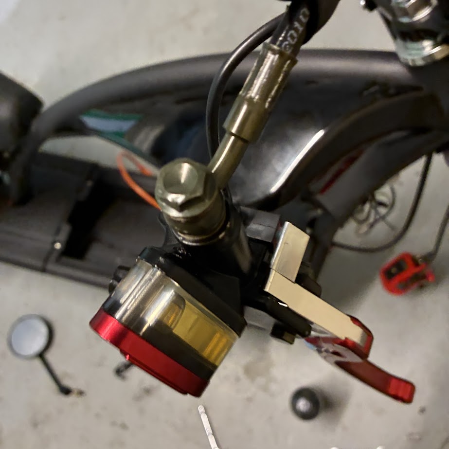 Close-up of a motorcycle's headlight assembly with brass and red components.