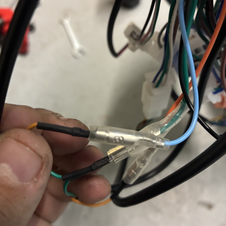 Close-up of hands working with electrical wires and a multimeter on a blurred background