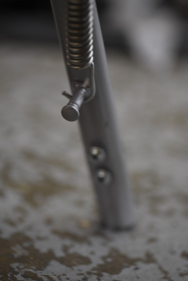 Close-up of a kick stand with screws on a blurred background