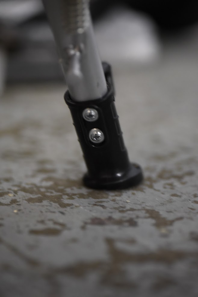 Close-up of a black and silver kickstand on a textured surface